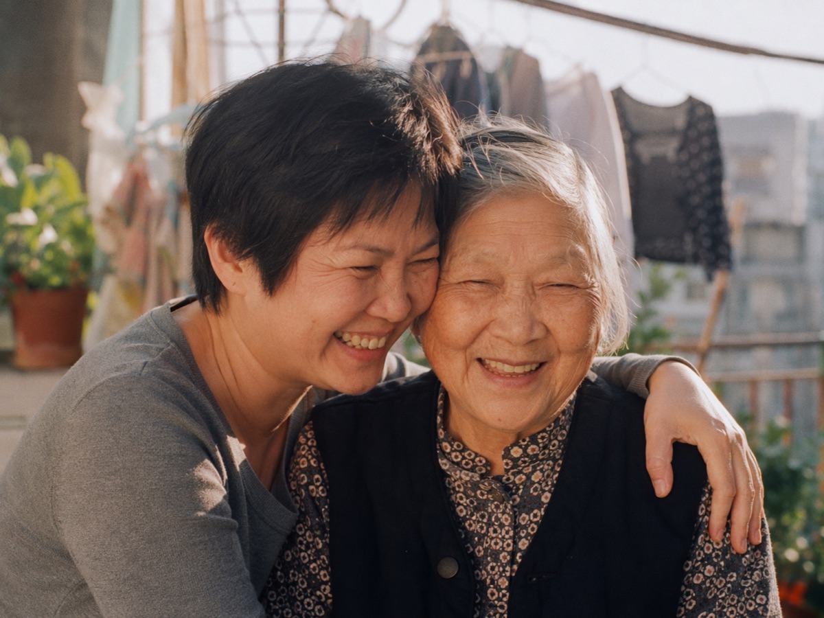 A Chinese adult daughter embracing her elderly mother, both smiling