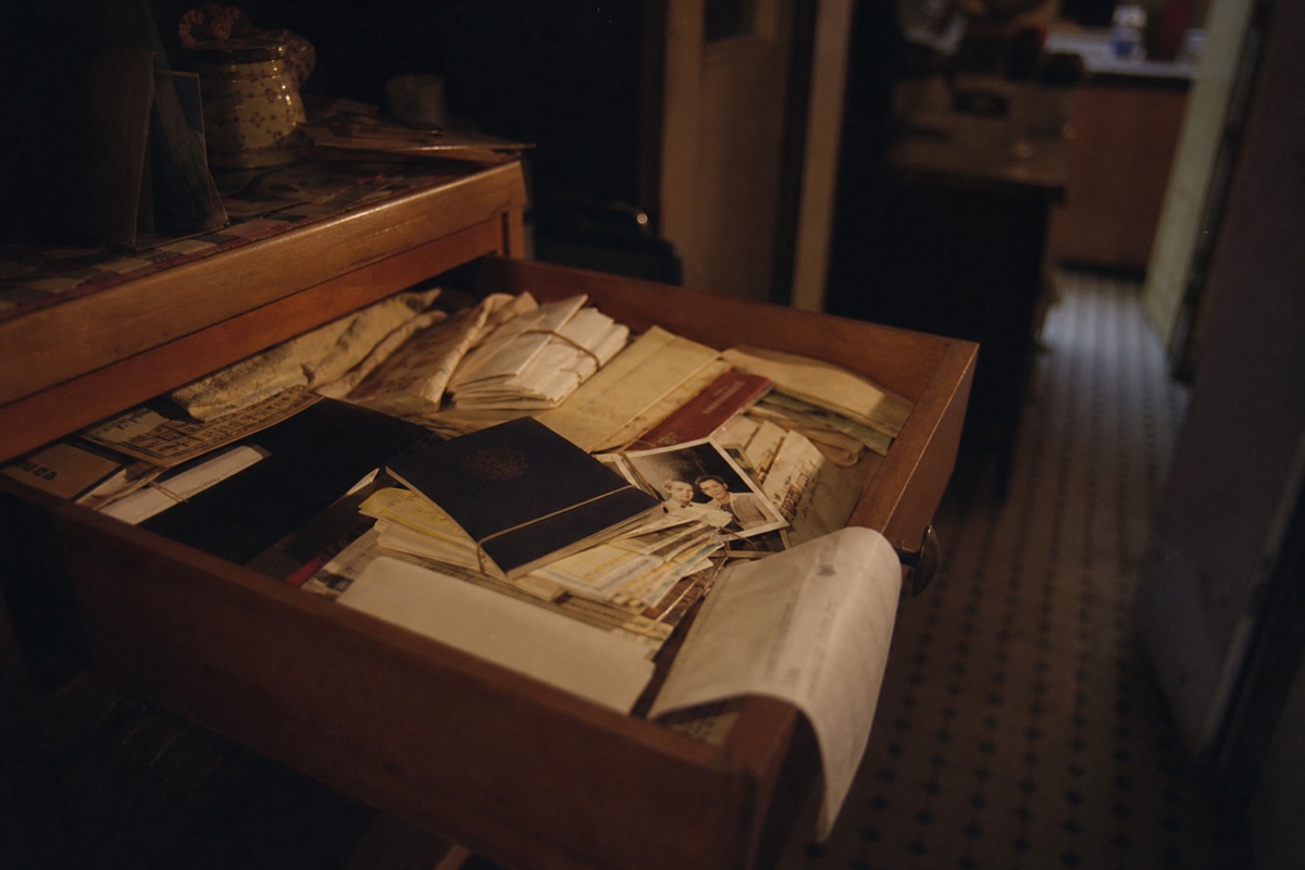 A wooden drawer overflowing with decades of unsorted papers, envelopes and old photographs